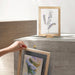 Framed artwork on a concrete surface with a neutral background