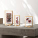 Three wooden picture frames with floral prints on a concrete surface.