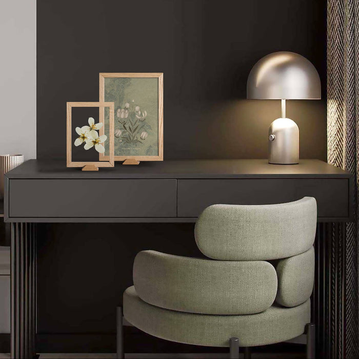 Modern interior with a dark wall, framed artwork, and a chair.