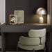 Modern interior with a dark wall, framed artwork, and a chair.