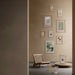 Wall with framed pictures and a chair in a room with a neutral color scheme