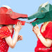 two children wearing a green and a red dragon mask