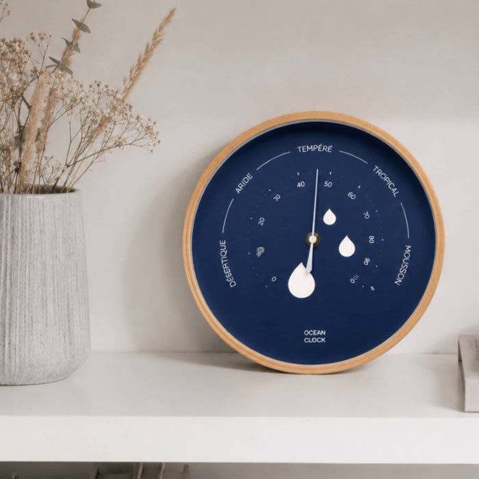 Wall clock with a blue face and wooden frame on a white shelf.