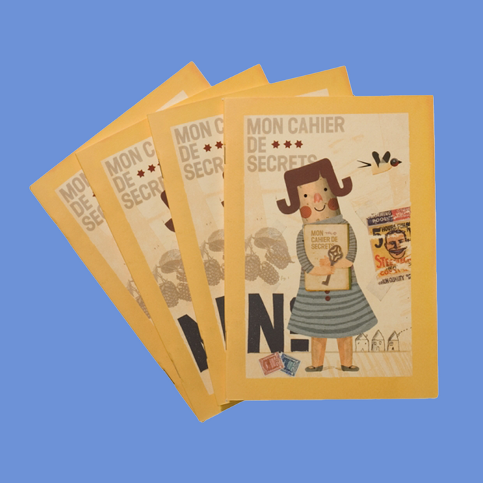 Four copies of a yellow notebook with illustration of female doll with the text "Mon Cahier De Secrets".