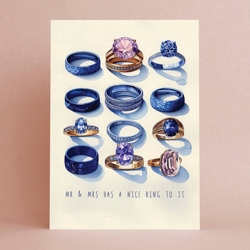 A square art print featuring an illustration of various rings, with the text 'MR & MRS HAS A NICE RING TO IT' at the bottom, displayed against a soft pink background.