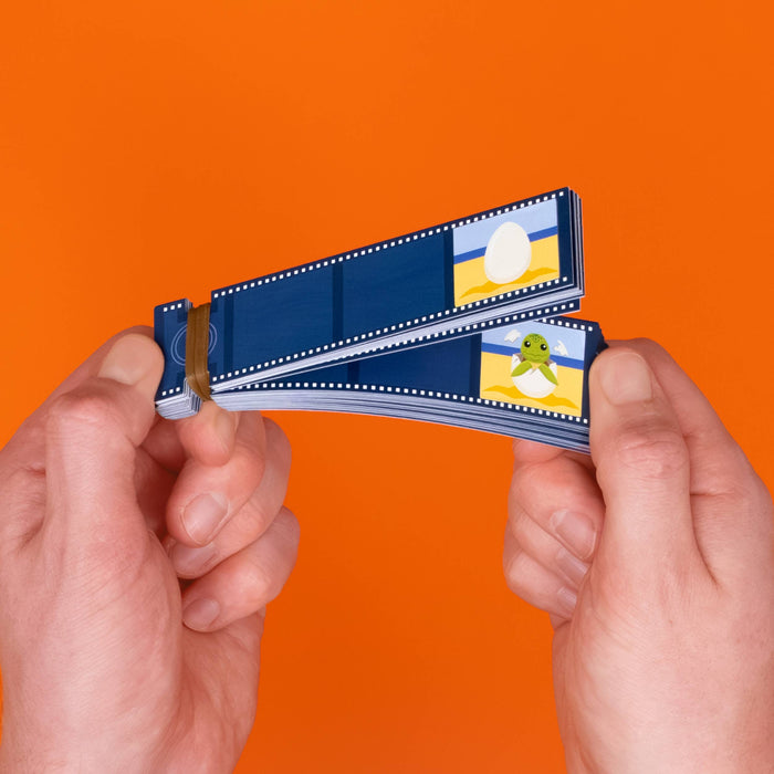 Two hands holding a stack of blue film strips with small printed illustrations, set against a solid orange background.
