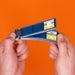 Two hands holding a stack of blue film strips with small printed illustrations, set against a solid orange background.
