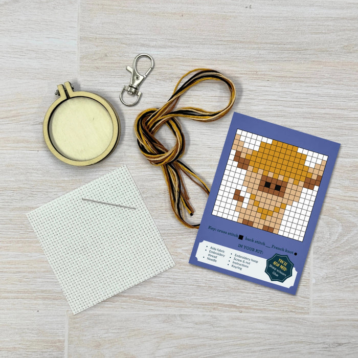 cross stitch set featuring components, embroidery hoop, instructions, thread, nedle and keyring