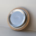 Metallic container with wooden lid on a light gray background