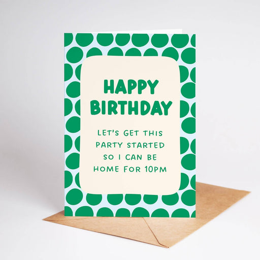 A green and white polka dot patterned birthday card with the text 'HAPPY BIRTHDAY LET'S GET THIS PARTY STARTED SO I CAN BE HOME FOR 10PM' in green lettering, displayed with a brown envelope on a light gray background.