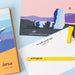 Greeting cards with artistic designs and a yellow pen on a light blue background