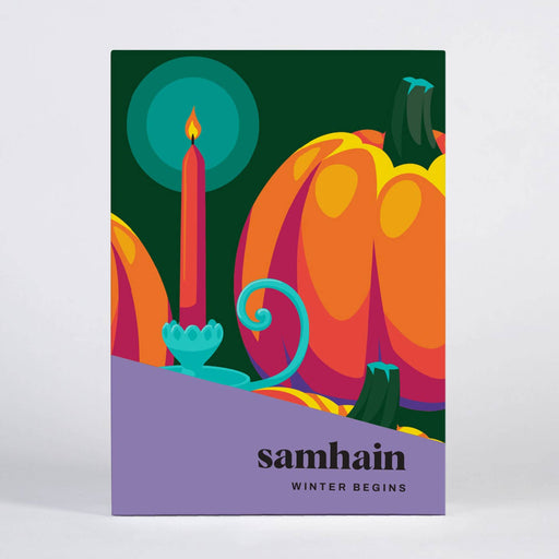 A square art print or book cover titled 'samhain WINTER BEGINS' featuring a stylized autumn scene with orange pumpkins, a teal candle, and a purple foreground band on a light gray background.