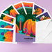 A set of colorful autumn-themed greeting cards fanned out with white envelopes on a light purple background. The central card reads 'samhain WINTER BEGINS' and features a stylized illustration of orange pumpkins, a teal candle, and a dark green background.