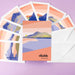 Set of greeting cards with mountain designs and an envelope on a purple background