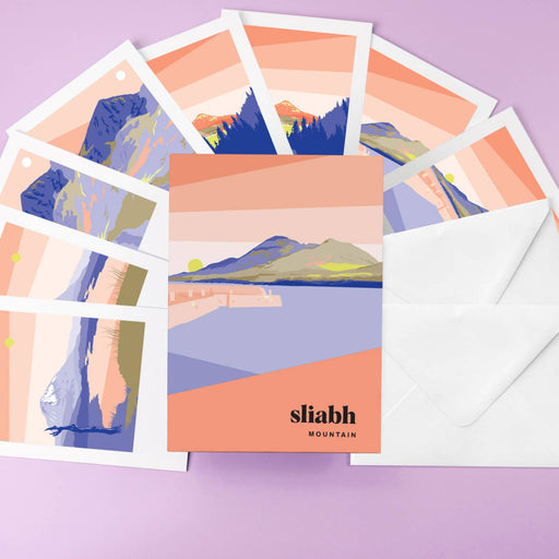 Set of greeting cards with mountain designs and an envelope on a purple background