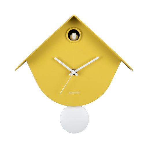 Yellow birdhouse-shaped clock with a white pendulum on a white background