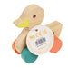 Wooden toy duck with colorful wheels and a label on a white background