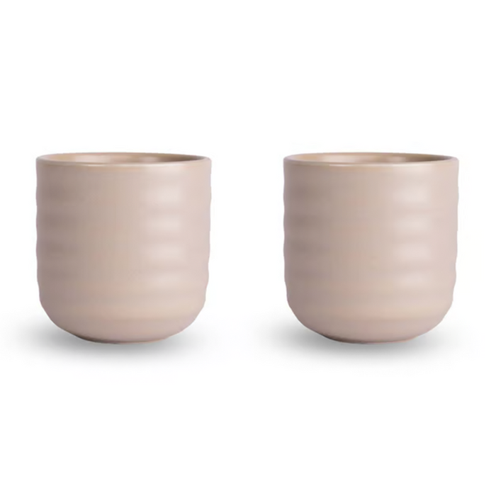 Two matching ribbed ceramic cups in a light warm beige color, shown side by side on a clean white background.