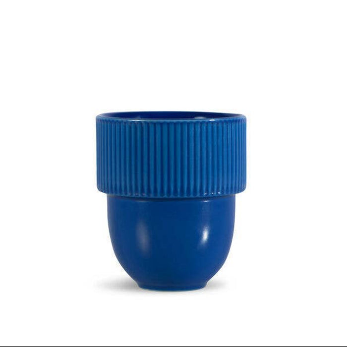A blue cup with a ribbed upper band and a smooth dome-shaped base, centered on a plain white background.