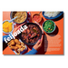 A magazine-style food spread on a bright orange background, featuring a central black bowl of feijoada with hands holding it, surrounded by side dishes including rice, greens, yellow fruit, fried items, and salsa. Large white text reads 'feijoada' and smaller text includes 'black bean feijoada.