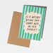 Card with humorous text on a striped background, placed on a plain surface