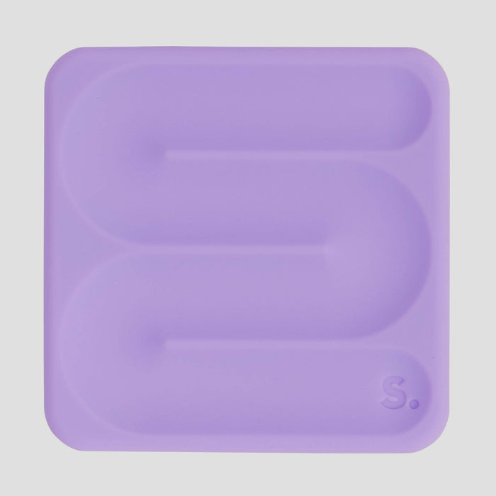 A lavender purple silicone tray with a wavy, serpentine channel design and a small embossed 'S.' logo in the bottom right corner, shown on a light gray background.