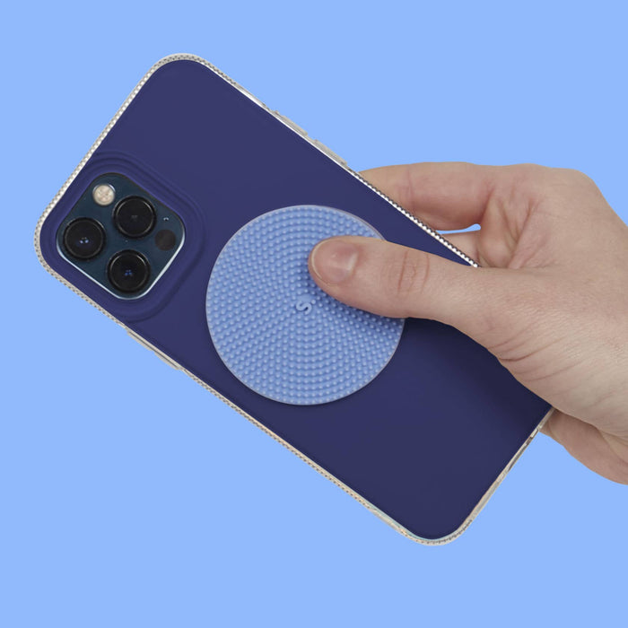 Hand holding a blue phone case with a textured circular design on a blue background
