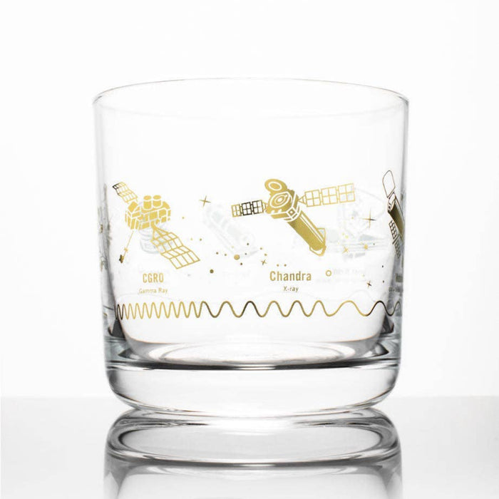 A clear glass rocks tumbler featuring gold space-themed illustrations of the Chandra and CSRO satellites, set against a clean white background with a soft reflection.
