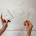 Hands holding a wine box and glass with 'Vinoos' branding on a light background