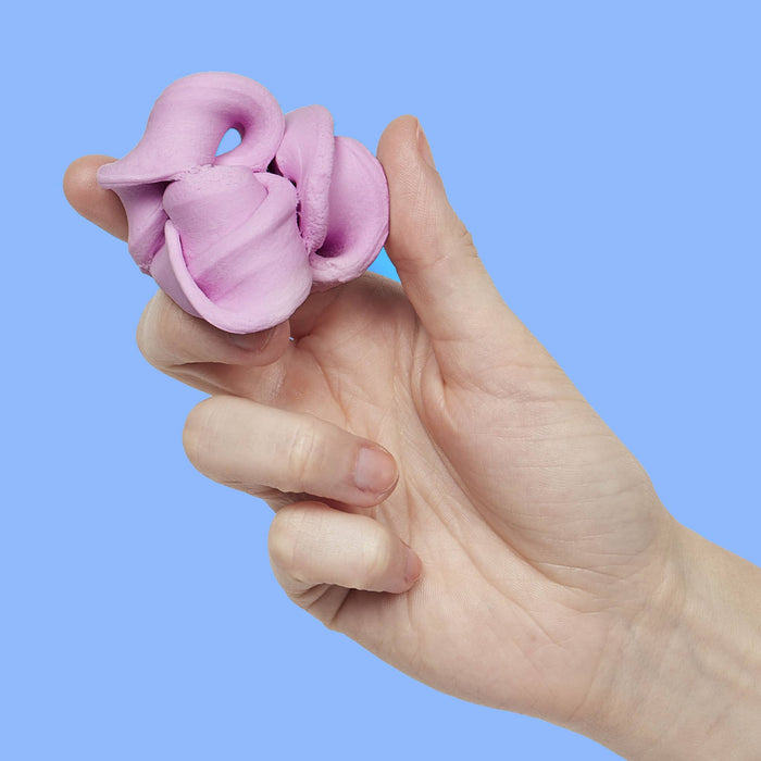 Hand holding a pink knotted object against a blue background