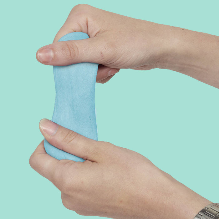 Hand holding blue putty against a light green background