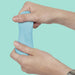 Hand holding blue putty against a light green background