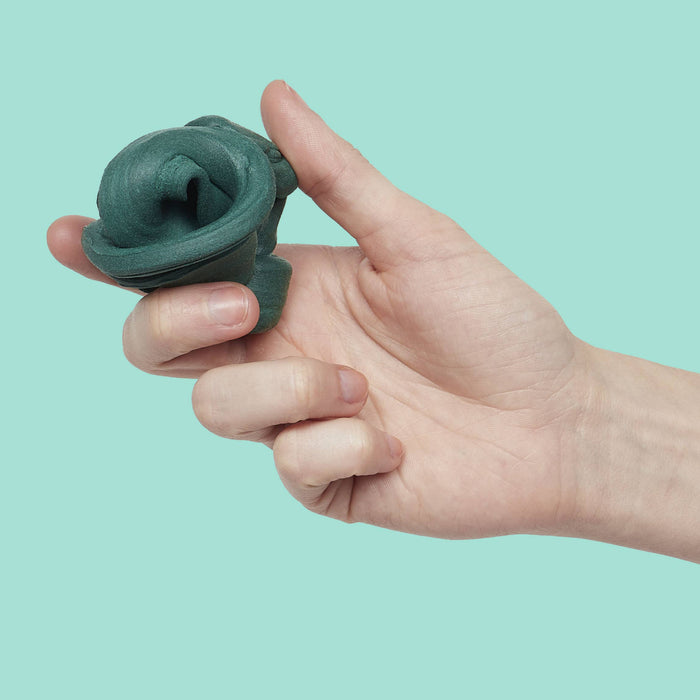 Hand holding a green silicone ring against a light blue background