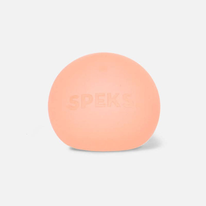 A peach-colored oval silicone or rubber product with the brand name 'SPEKS' embossed on the front, set against a plain light gray background.
