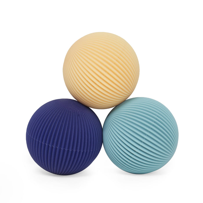 Three textured balls in beige, blue, and teal on a white background