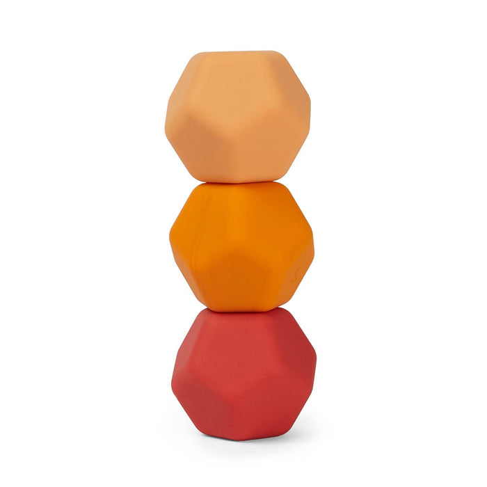 Stack of three geometrically shaped objects in orange, red, and brown on a white background