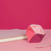 Pink geometric object on a pink surface with a pink background