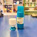 Teal water bottle with 'Dopper' branding and white cup on a blue surface.