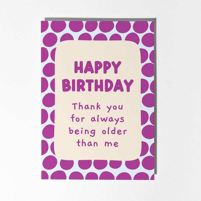 Birthday card with purple polka dot border and humorous message on a light background