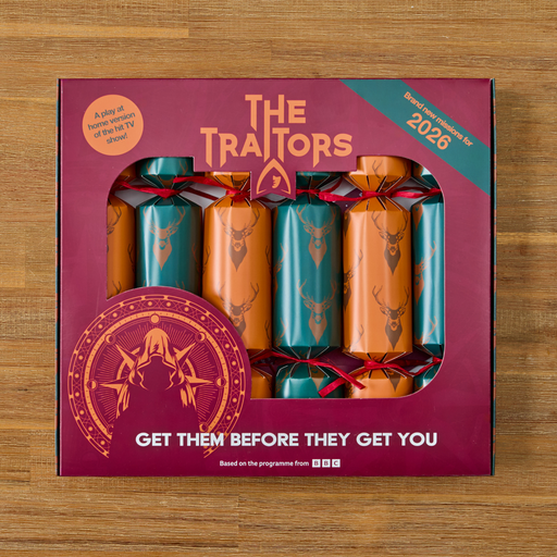 A boxed set of five cracker fireworks on a wooden surface. The packaging is dark magenta with gold lettering reading 'THE TITANS' and 'GET THEM BEFORE THEY GET YOU,' plus a teal 'Based on the programme by 2026' banner.