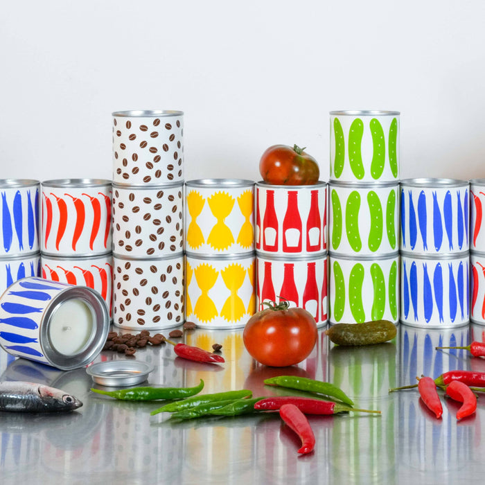 Colorful stacked cans on a reflective surface with tomatoes and peppers.
