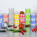 Colorful stacked cans on a reflective surface with tomatoes and peppers.