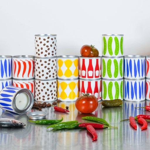 Colorful stacked cans on a reflective surface with tomatoes and peppers.