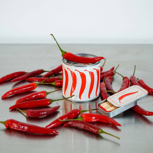 Canned food with red chili peppers on a gray surface
