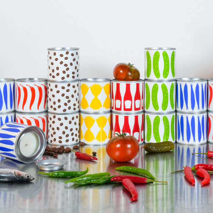 Colorful stacked cans on a reflective surface with tomatoes and peppers.