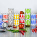 Colorful stacked cans on a reflective surface with tomatoes and peppers.