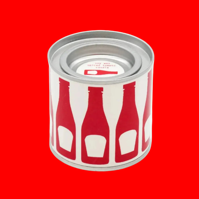 Cylindrical tin candle container with red and white bottle design on a blue background