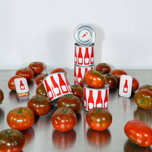 Tomatoes and cans with red and white labels on a reflective surface