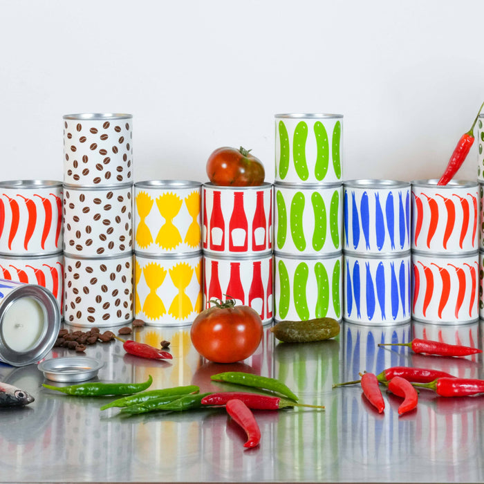 Colorful stacked cans on a reflective surface with tomatoes and peppers.