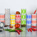 Colorful stacked cans on a reflective surface with tomatoes and peppers.